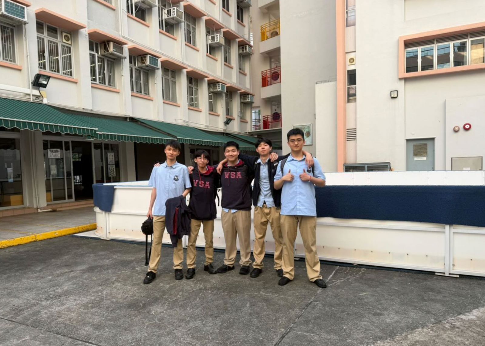 Five AI For Good members in the courtyard of Ho Man Tin Ling To Catholic School.