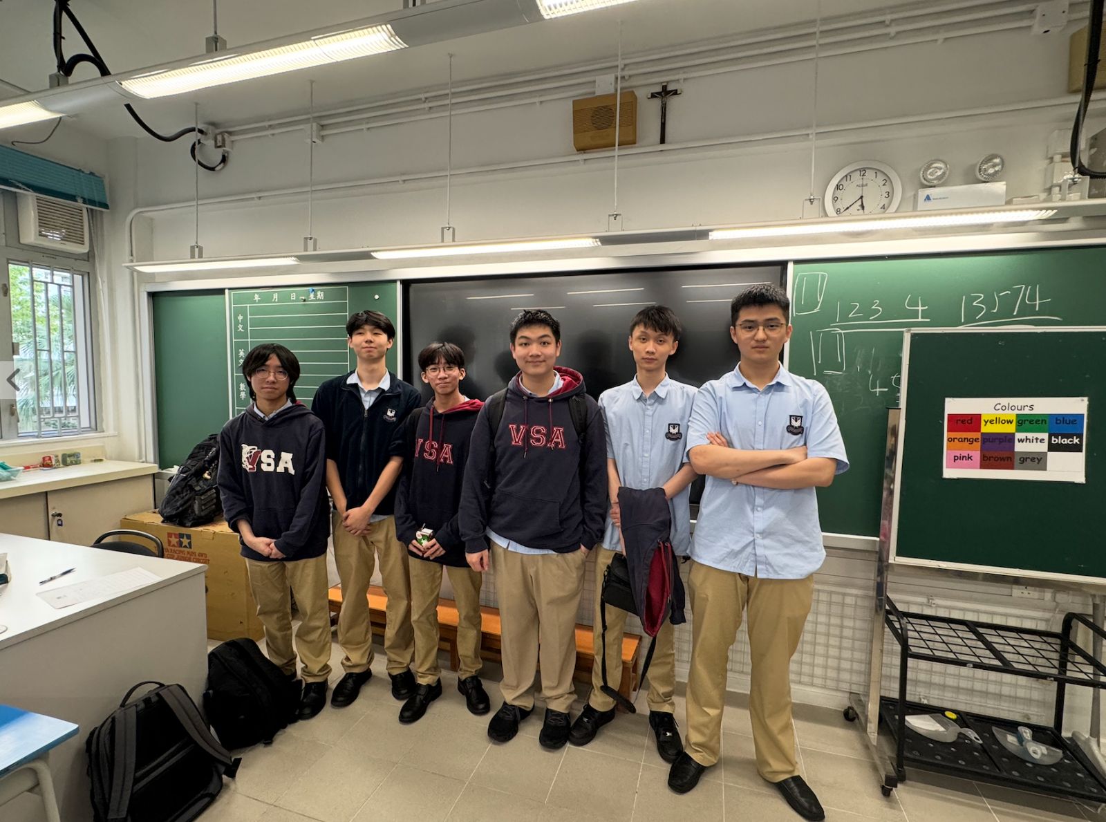 Six AI For Good members in a classroom at Ho Man Tin Ling To Catholic School after a session.