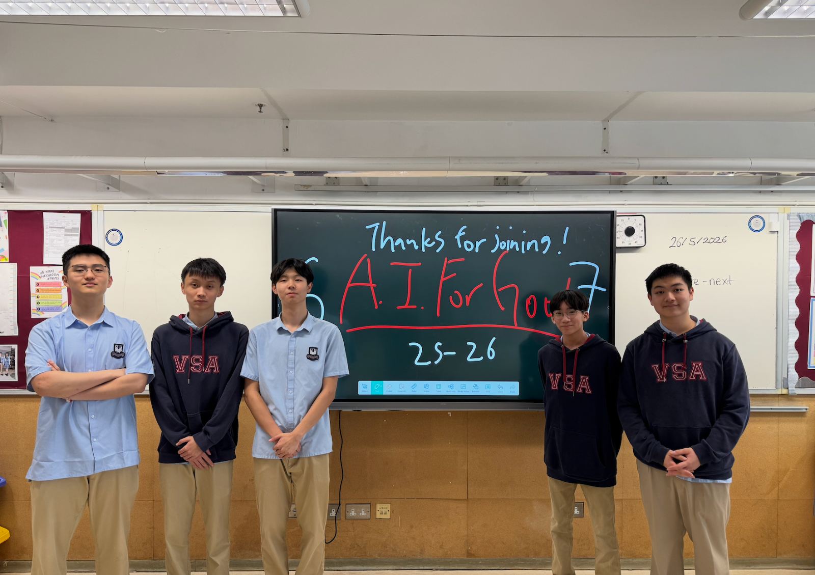 Tutors in front of a board reading "Thanks for joining — A.I. For Good 25–26" at the end of the year.