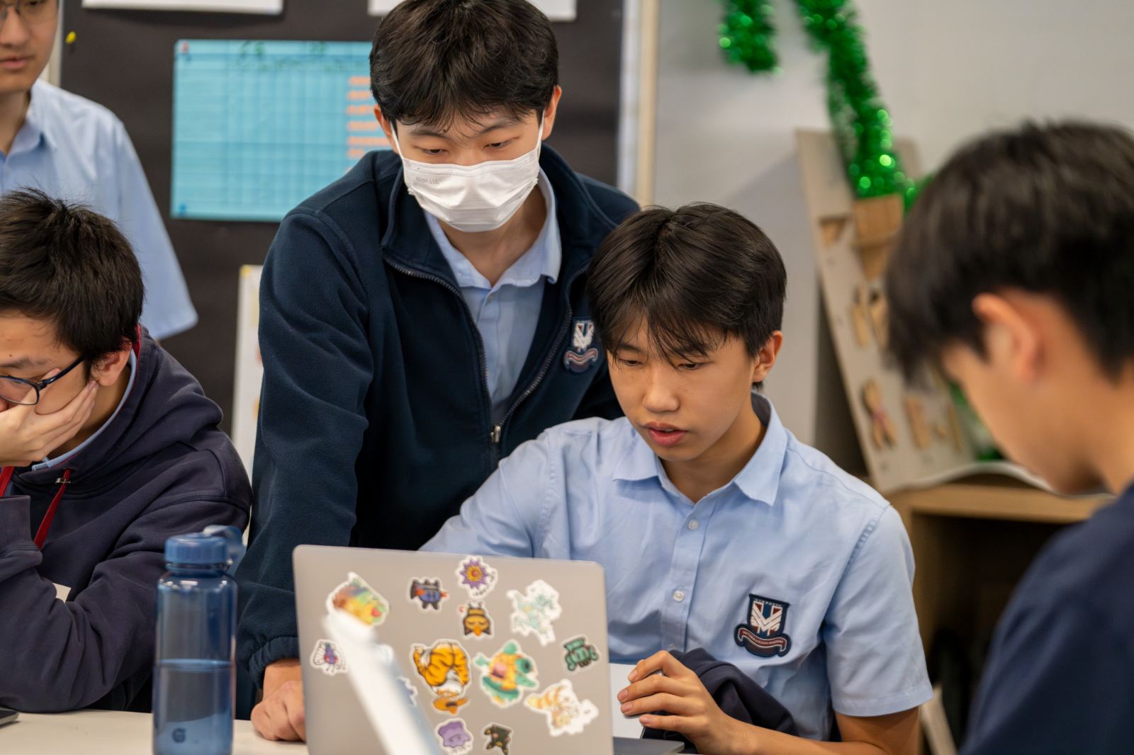 A tutor helps a student at a laptop during a session.